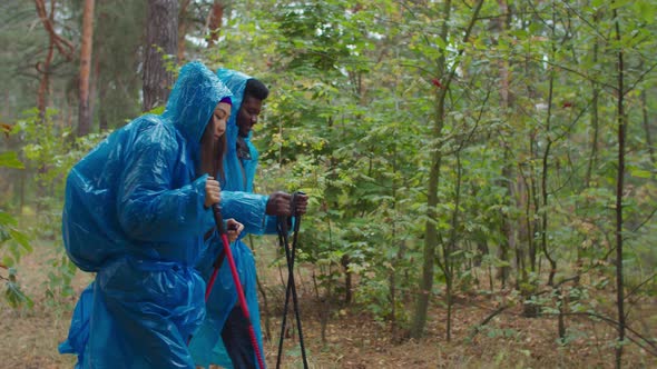 Hiking Couple in Raincoats Backpacking in Nature