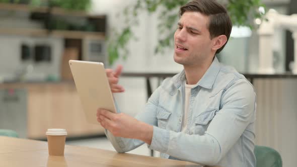 Creative Young Man Making Video Call on Tablet at Work