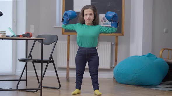 Smiling Caucasian Female Little Person Bumping Boxing Gloves Gesturing Strength Looking at Camera