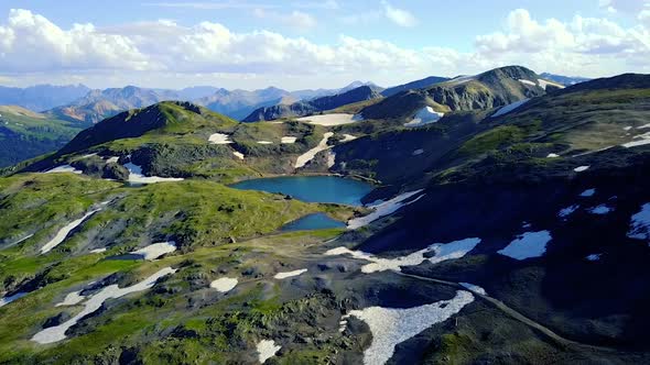 Aerial View of Drone Flying High Up In the Colorado Rockies Toward Hidden Mountain Lake and Snow 