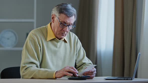 Focused Elderly 60s Caucasian Man Sitting at Desk Manage Finances Planning Budget Check Bills Use