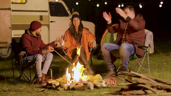 Bearded Man Telling a Funny Joke To His Friends Around Camp Fire