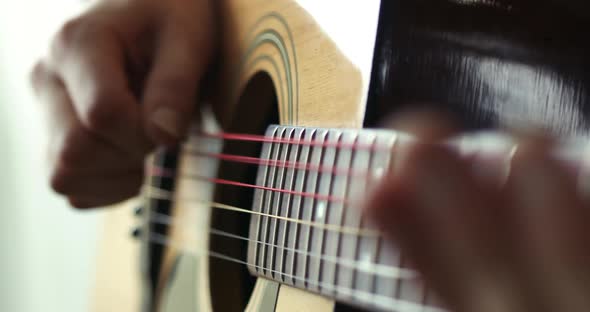 Strumming a guitar close up in super slow motion 300fps