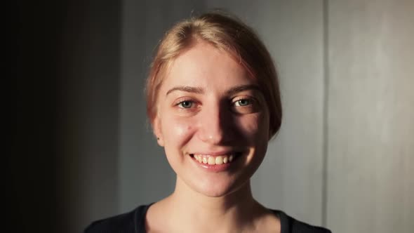 Portrait of a happy young woman laughing and looking at camera