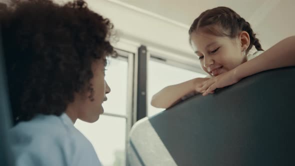 African American Girl Talking with Classmate in Bus