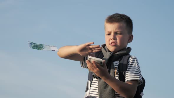 Boy Throws Money Into the Air