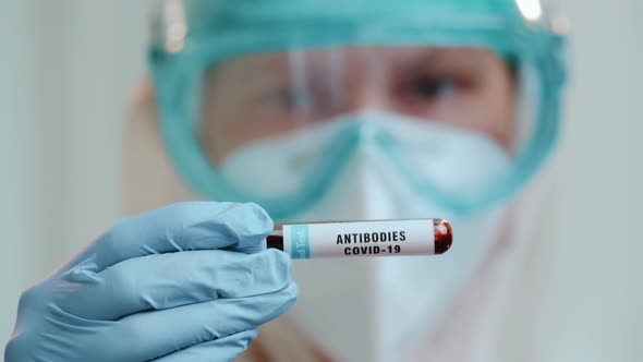 Female Doctor with Test Tube of Antibodies COVID-19 Against Coronavirus