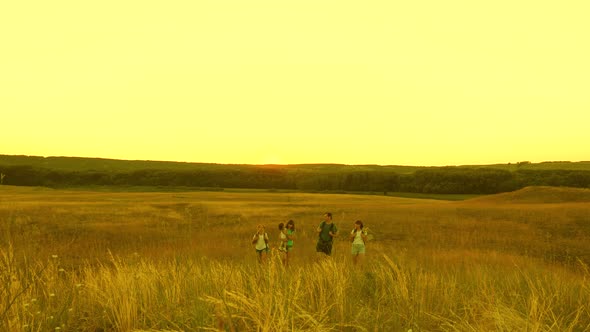 Travelers Teamwork. Happy Family of Travelers Ascends To Their Victory, To the Top of the Hill