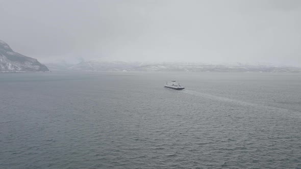 Ferry between Olderdalen and Lyngseidet in Kåfjord, Norway. Overcast winter fog. 4k rear follow dro