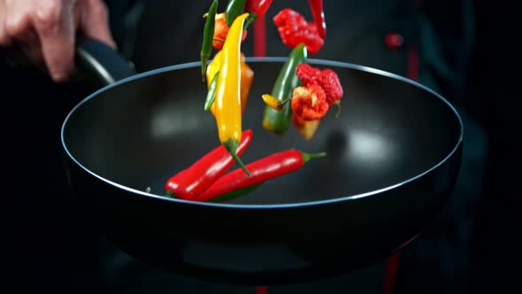 Super Slow Motion Shot of Chef Holding Frying Pan and Falling Chilli Peppers at 1000Fps