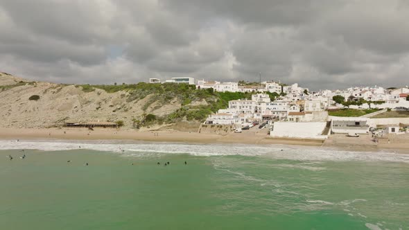 Aerial shot of surfers outside a small coastal town waiting to catch waves