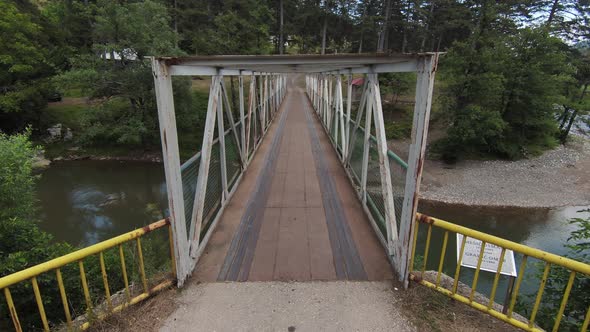 Skilled Flying of FPV Drone Inside Iron Bridge Over the River on Sunny Summer Day