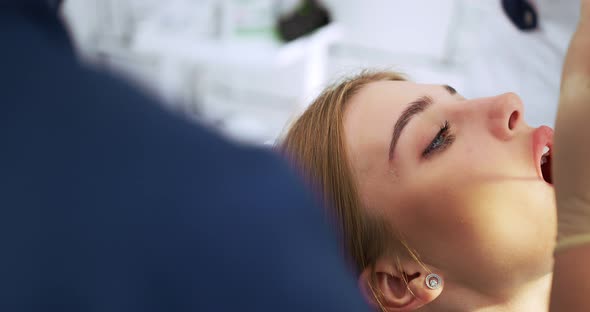 the Dentist Performs an Examination Using a Dental Mirror a Woman