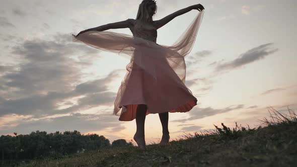 The Girl in the Dress Swirls Magically at Sunset