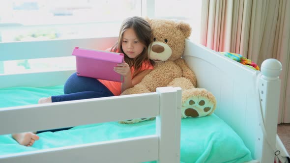 Girl using digital tablet on bed in bedroom 4k