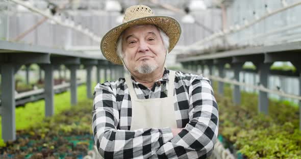 Close-up of Confident Senior Caucasian Man with Brown Eyes in Straw Hat Looking at Camera, Portrait