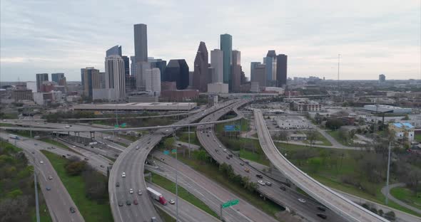 Aerial view of traffic on freeway near downtown Houston on a cloudy day during sunset. This video wa