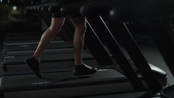 Athletic Runner Man Run on a Treadmill Aerobic Exercise and Endurance Training in the Gym Night