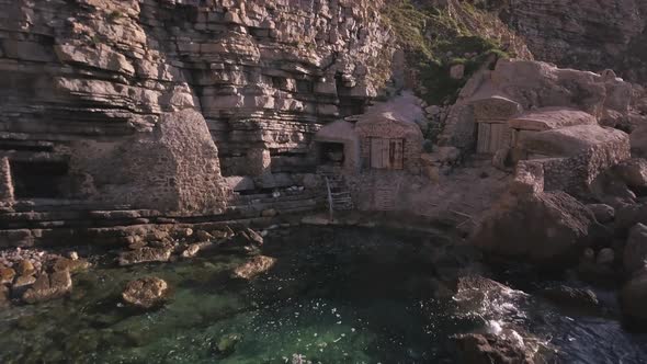 Intriguing hidden fisherman's huts on the rocky water's edge Ibiza, drone