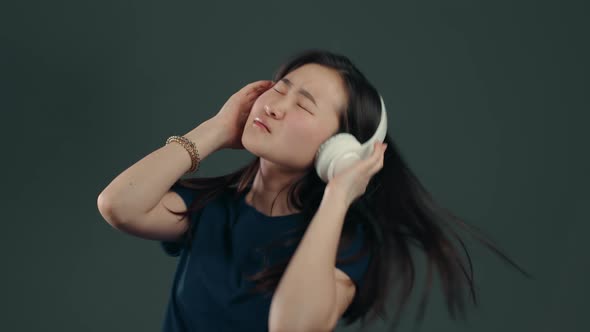 Pretty Asian Girl with Long Hair Having Fun, Smiling, Dancing with Headphones