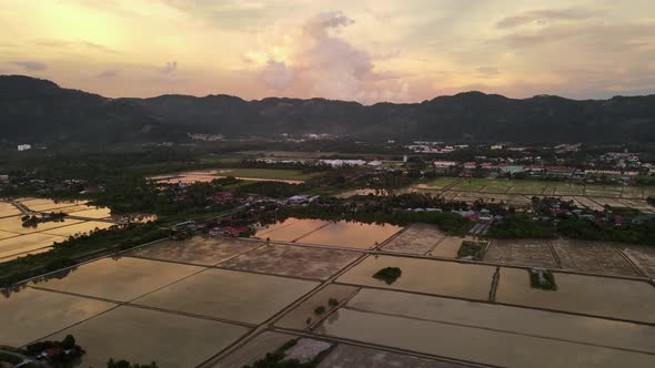 Aerial view dramatic sunset at water season paddy field