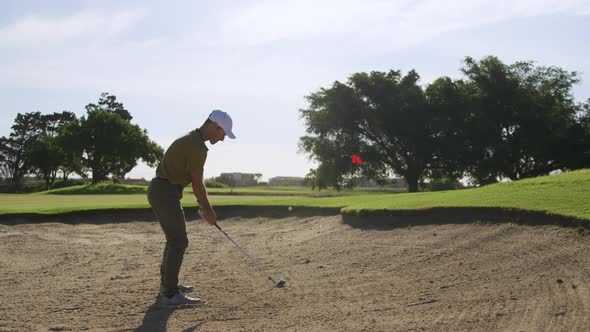 Golf player hitting the ball with his club