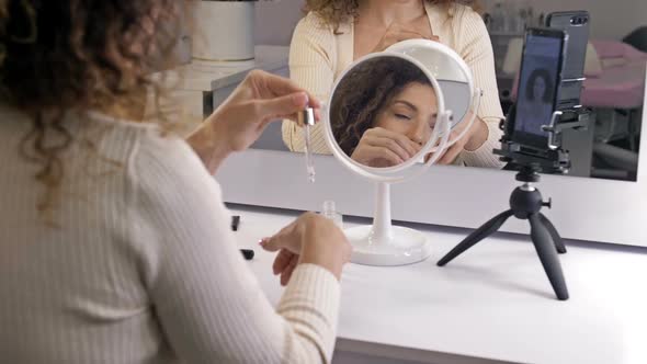 Beautiful Middle Aged Woman Demonstrates the Application of a Moisturizing and Nourishing Cosmetic