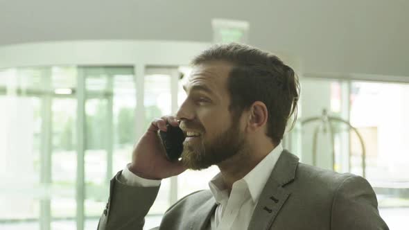 Businessman using cellphone, smiling cheerfully