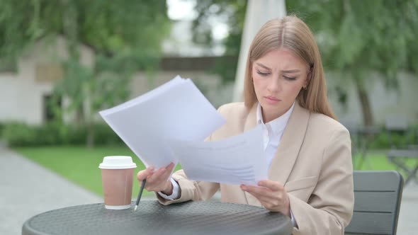Young Businesswoman Celebrating Success While Reading Documents