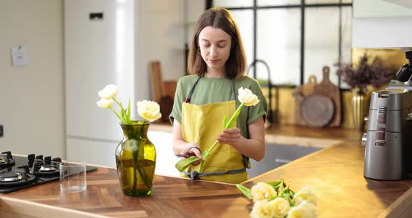 Woman Decorates Home Interior with a Bouquet of Fresh Flowers