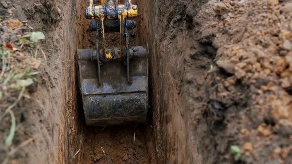 Mini Excavator Digs a Trench to Lay Pipes