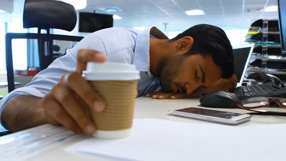Male executive sleeping at desk