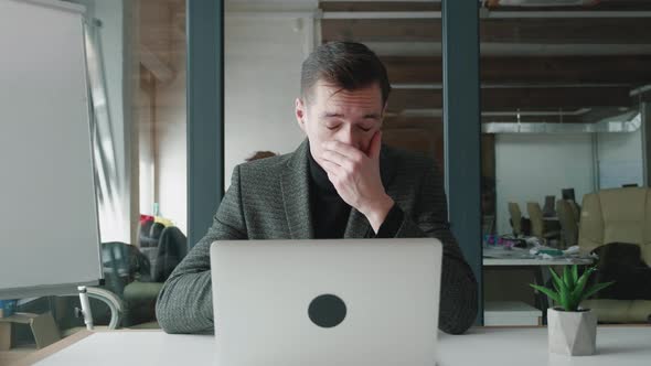 Young Business Man Suffering with Allergies in an Office