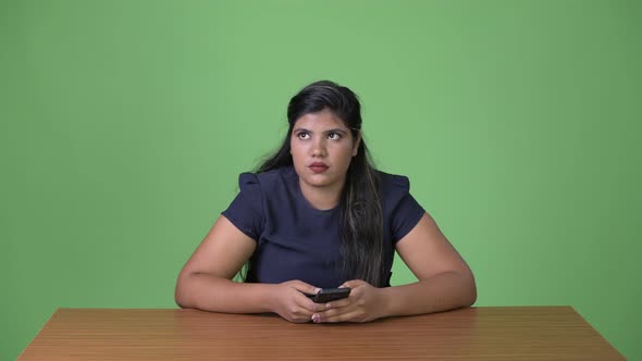 Young Overweight Beautiful Indian Businesswoman Against Green Background