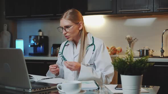 Video Call to Patient Female Doctor in Medical Gown Explaining How to Take Medicine