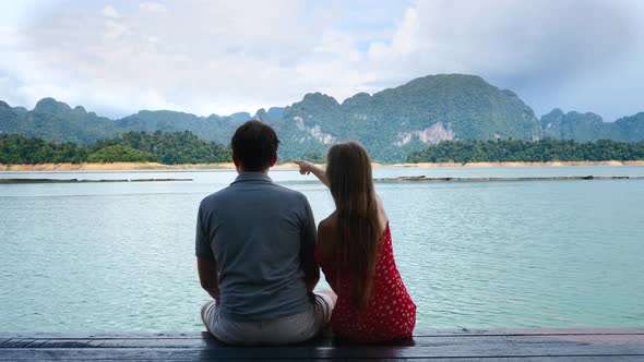 Happy Couple in Love Saw Something and Point By Finger on Green Mountains Lake