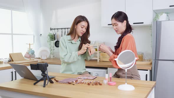 Beautiful Beauty blogger Influencer woman couple live streaming and showing makeup in kitchen.