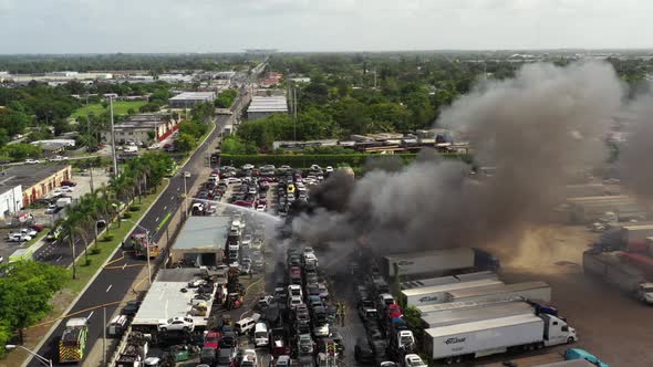 Aerial Footage Firefighters In Action Putting Out Fire At A Car Junk Yard