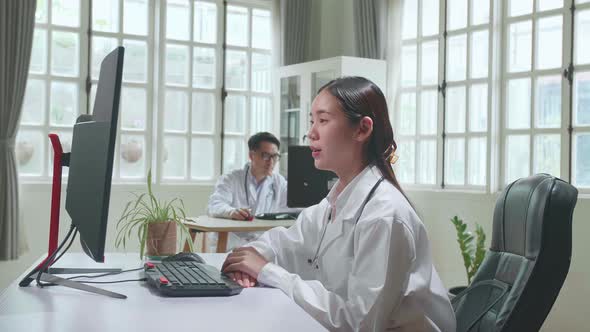 Asian Female Doctor Communicates With Patient By Video Link, Doctor Consults Patient