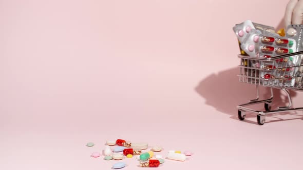 Closeup of Different Medical Pills in the Basket on Pink Background