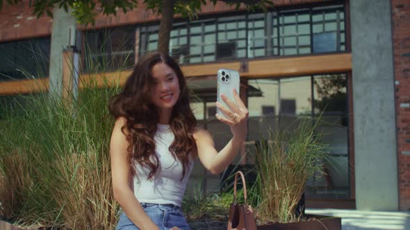 Asian Girl Photographing Herself Sitting City Bench