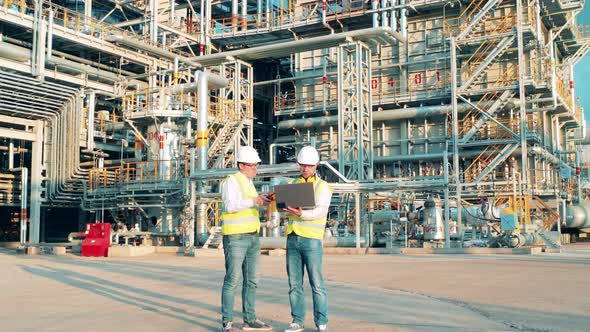 Work Partners are Talking in the Middle of the Petroleum Refinery