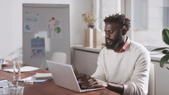 African American Office Worker Using Laptop