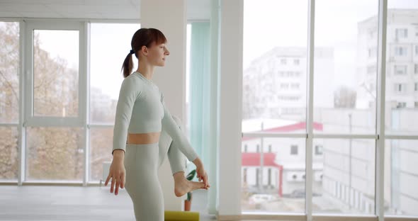 Young Woman Practices a Yoga in Bright Studios Utthita Hasta Padangusthasana