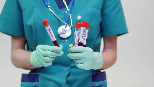 Medical Doctor Nurse Woman Wearing Protective Mask and Latex Gloves - Holding Blood Test Tube