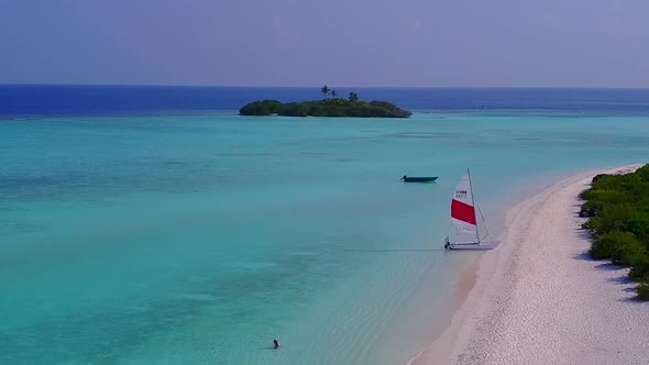 Drone travel of shore beach by blue water and sand background