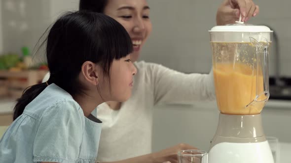 Woman and little girl with electric blender