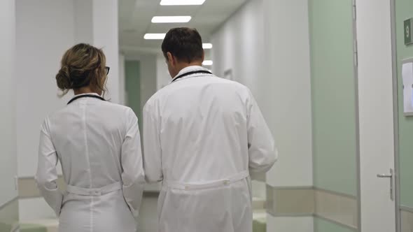 Healthcare Coworkers Walking and Talking in Hospital