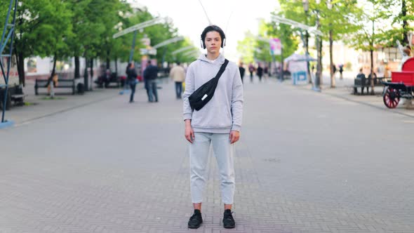 Time-lapse of Teenager in Headphones Listening To Music Standing in the Street