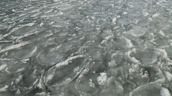 Broken ice sheets ripple with waves LOW ANGLE AERIAL